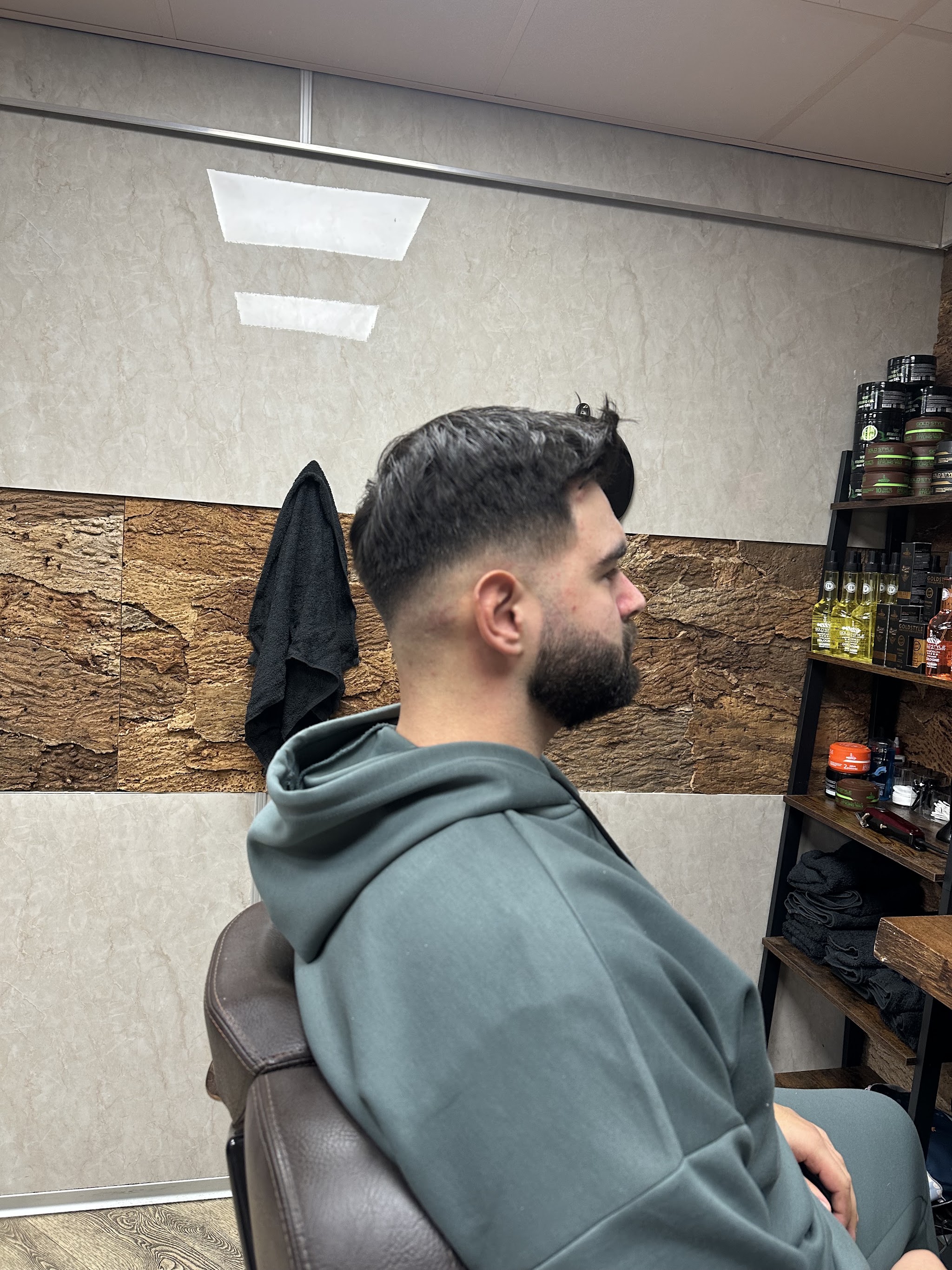 Klant van opzij na een fade met een strak bijgewerkte baard