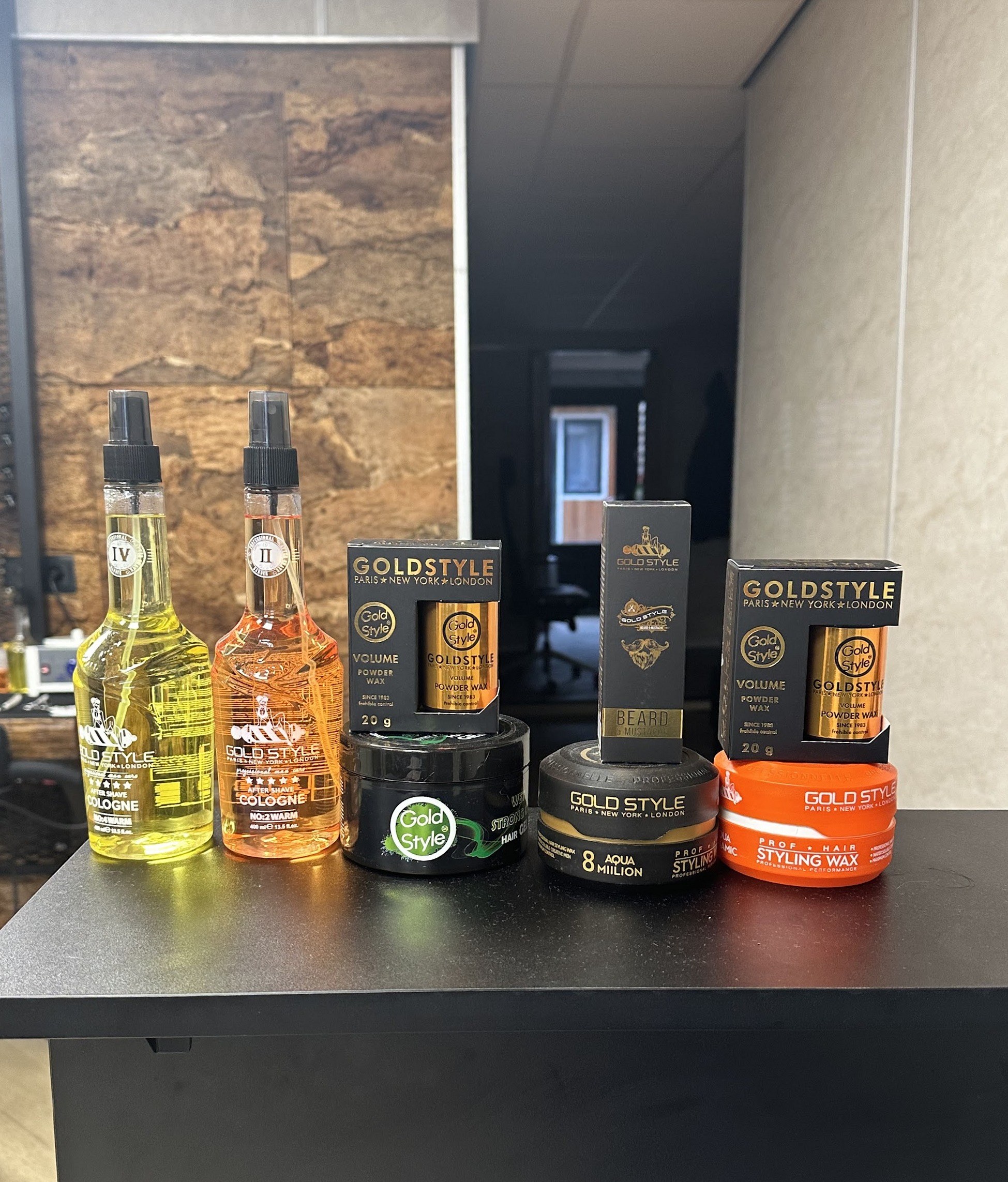 Producten van GoldStyle op de zwarte balie: haarlotion, wax en stylingproducten